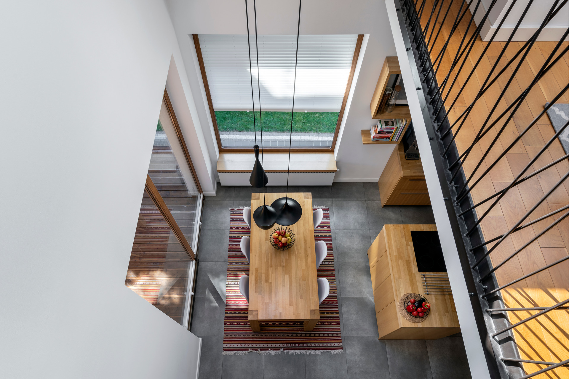 Modern dining room with wood table, pendant lights, and large windows